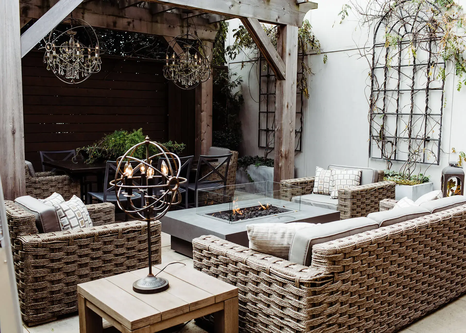 outdoor patio area cafe rule garden seating with fire side table and mood lighting green vegetation comfortable outdoor chairs and sofa left side