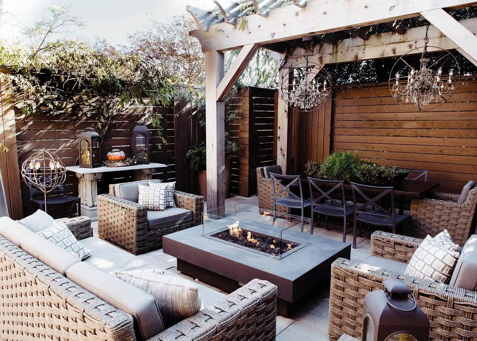 outdoor patio area cafe rule garden seating with fire side table and mood lighting green vegetation comfortable outdoor chairs and sofa