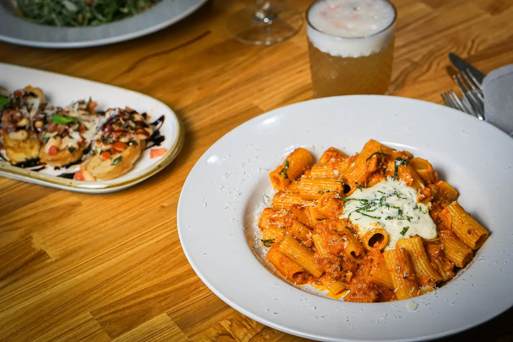 rule prime pasta closeup dining table scene with creamy pasta dishes drinks textures soft lighting warm mood hickory nc